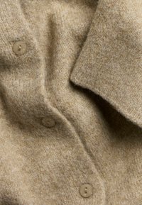 Beige wollen cardigan met een zachte textuur, knoopsluiting aan de voorkant en een notch-kraagontwerp met zichtbare stiksel-details.