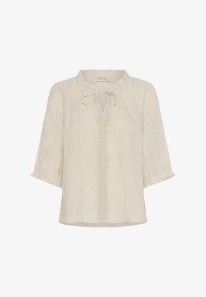 Kremasta lanena bluzica z nabranim ovratnikom, zavezovanjem in zapletenim čipkastim okrasjem spredaj. Kratki, nabranih rokavi.