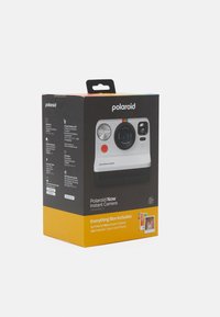Polaroid Now Instant Camera packaging features a black and yellow design, listing contents and specifications. Includes a camera and 16 color photos.
