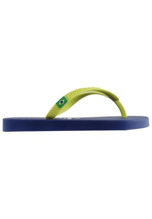 Chancla azul con una suela texturizada, correa de goma verde con el texto "Brasil" y un pequeño acento de bandera brasileña.