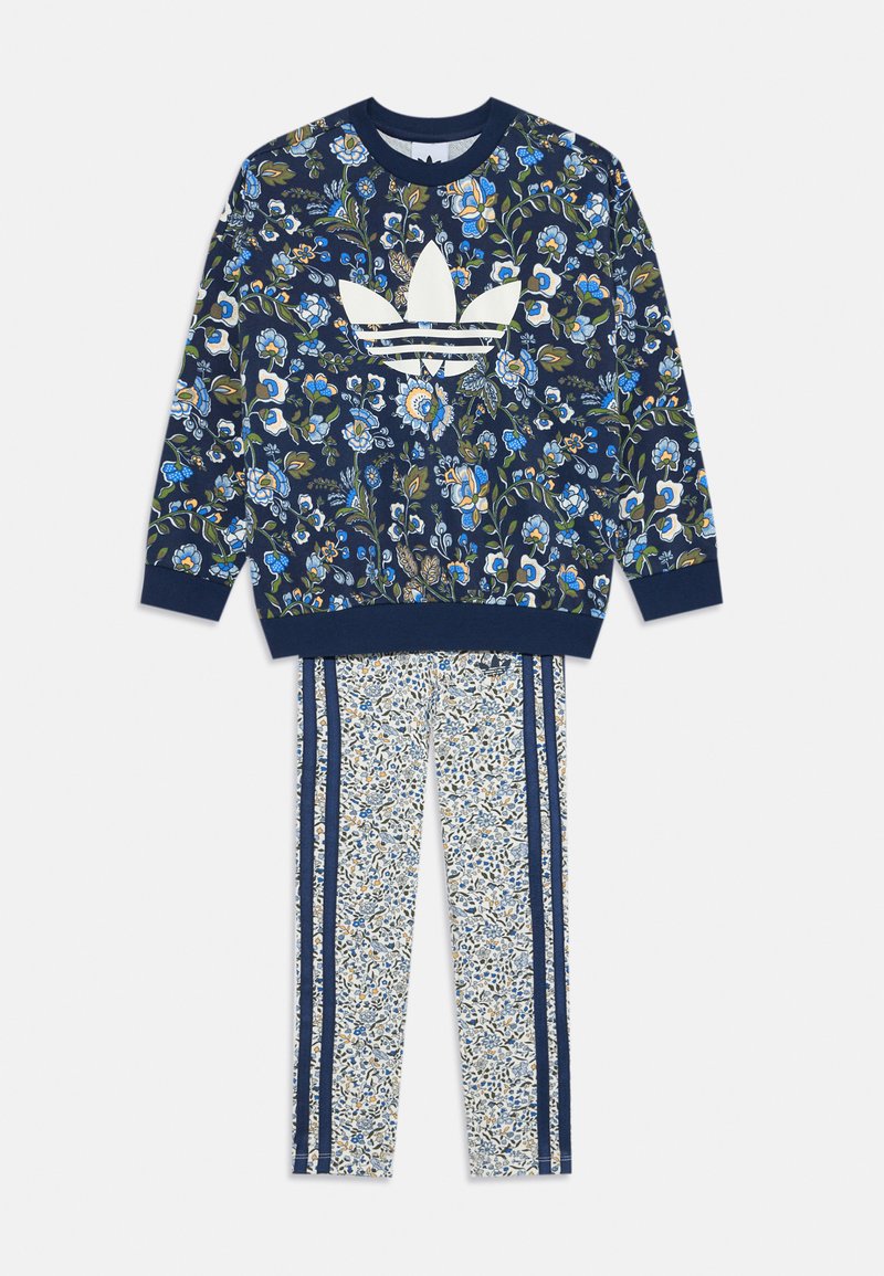 Džemper s cvjetnim uzorkom u tamnoplavoj boji s bijelim Adidas logom; odgovarajuće hlače s malim cvjetnim uzorkom i tamnoplavim bočnim trakama.