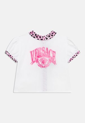 Top alb cu mâneci scurte, cu guler și manșete cu imprimeu leopard roz și negru, și logo Versace roz îndrăzneț cu cap de Meduză în față.