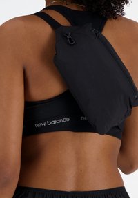 Sac à dos noir, léger, sécurisé sur le dos, doté d'une fermeture zippée et d'un design compact et épuré.