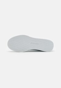 Bijela gumena potplat s teksturiranim uzorcima za bolje prijanjanje; sadrži logo "SKECHERS". Zaobljeni potplat i glatke ivice poboljšavaju udobnost i stabilnost.