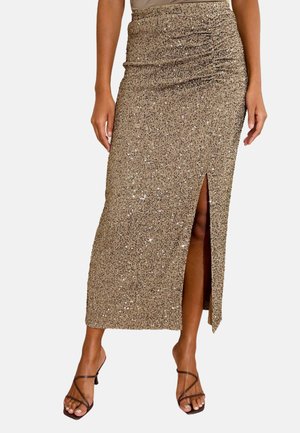 Maxi-Rock aus goldenen Pailletten mit einem seitlichen Schlitz und gerafftem Detail an der Taille. Die glatte Textur und die figurbetonte Silhouette heben das Design hervor.