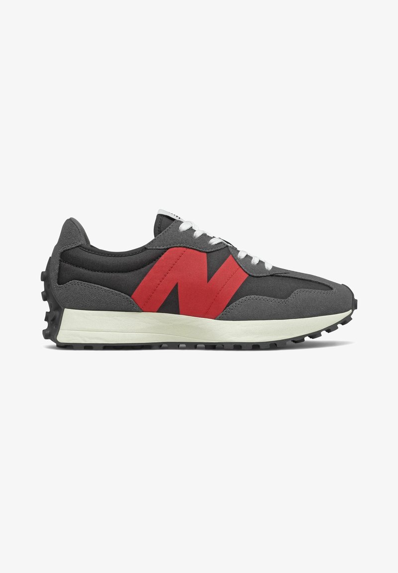 Baskets gris et noir style rétro avec logo latéral rouge, lacets blancs, semelle intermédiaire blanche épaisse et semelle extérieure noire cloutée.