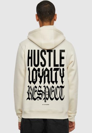 Cream hoodie featuring bold black text on the back: "HUSTLE LOYALTY RESPECT." Soft fabric, relaxed fit, with a drawstring hood.