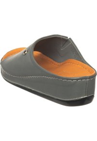 Chaussure en cuir gris sans lacets avec coutures blanches visibles, semelle intérieure orange matelassée et semelle noire, vue sous un angle arrière latéral.