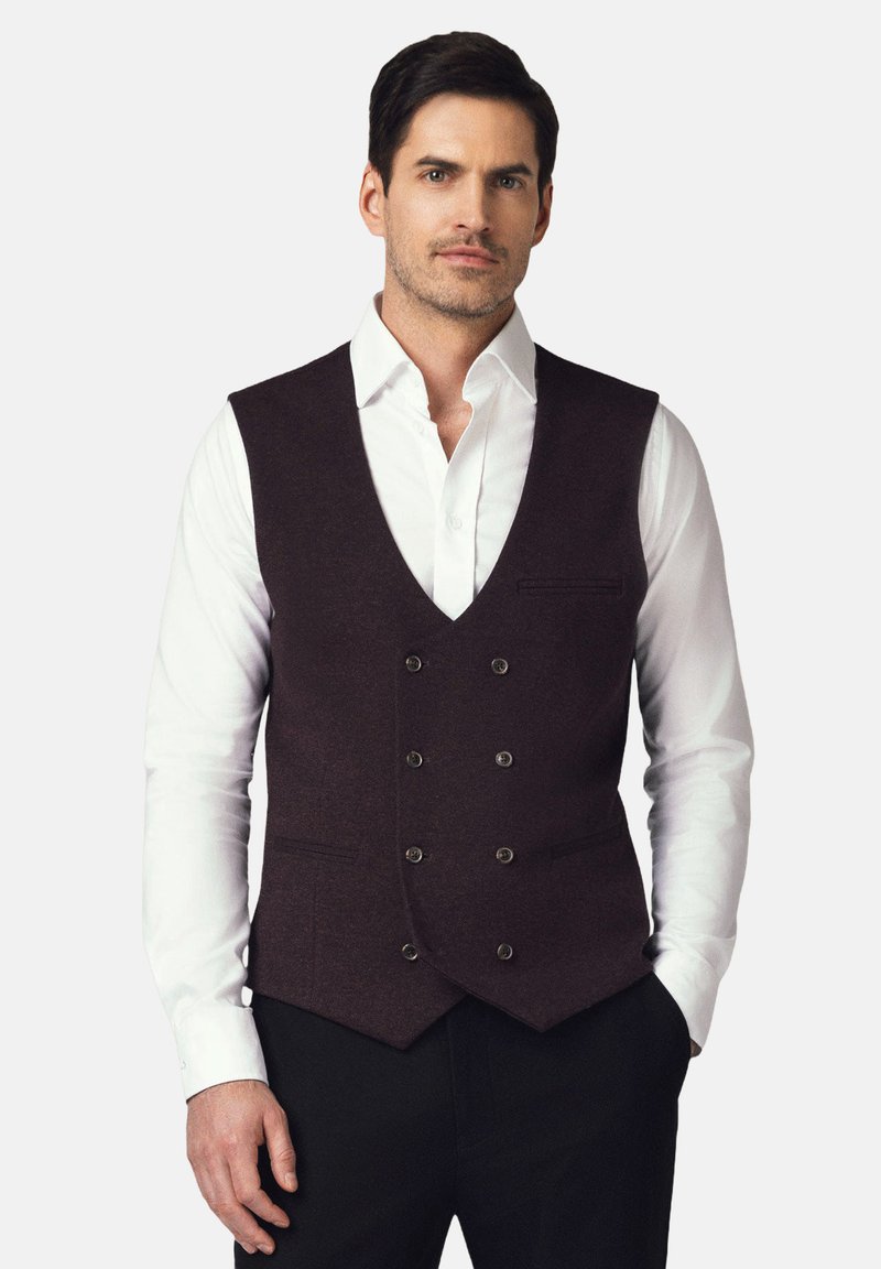 Bordowy wełniany kamizelka z dekoltem w kształcie V, zapinana na podwójne guziki, z dwoma bocznymi kieszeniami, noszona na białej koszuli.