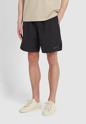 Schwarze Shorts aus leichtem Material, mit elastischem Bund und Seitentaschen. Auffälliges Logo-Detail am unteren Bein.