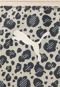 Geanta Puma cu un material bej deschis, cu imprimeu leopard negru și un logo alb în siluetă al unei pisici săritoare. Textură netedă, închidere cu fermoar.