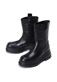 Botas de cuero negras hasta el tobillo con cremalleras laterales, puntas redondas y suelas texturizadas. Presentan un tacón grueso y detalles de costura.