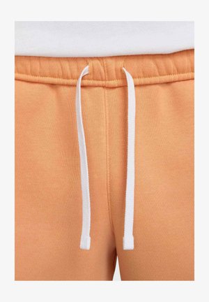 Oranje sweatpants hebben een zachte textuur, een elastische tailleband met witte trekkoordjes en gestikte naden voor duurzaamheid.