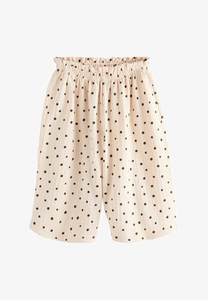 Short ample beige clair à pois noirs avec une taille élastique froncée.
