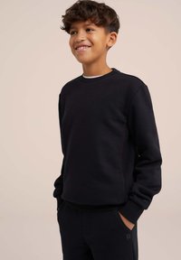 Črna kapuca iz mehkega materiala, z okroglo ovratnico, rebrastimi manšetami in diskretnim logotipom vtisnjenim na rokavu.