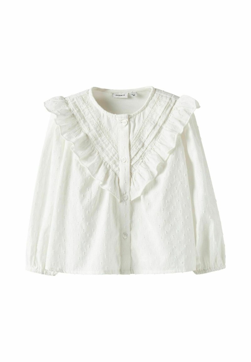 Balta medvilninė palaidinė su raukšlėtu apykakliu, užsegama sagomis ir tekstūruotu raštu su mažais iškilimais. Ilgos rankovės su surinktomis rankogaliais.