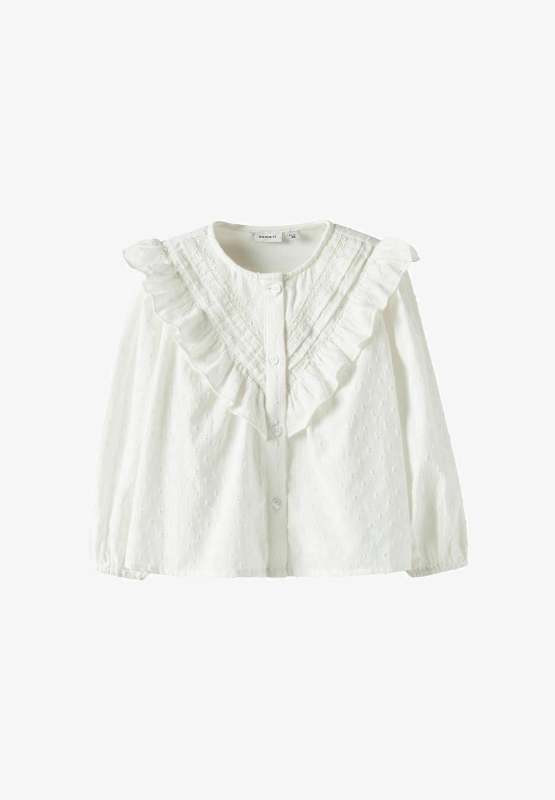 Balta medvilninė palaidinė su raukšlėtu apykakliu, užsegama sagomis ir tekstūruotu raštu su mažais iškilimais. Ilgos rankovės su surinktomis rankogaliais.