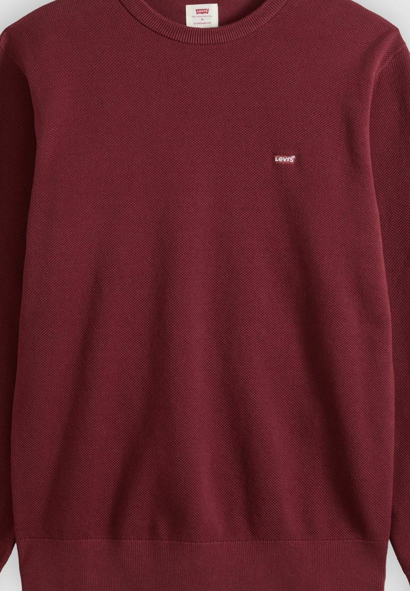 Suéter de manga larga texturizado Levi’s burdeos con cuello redondo y pequeño logo de Levi’s en el pecho izquierdo.