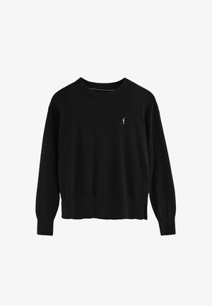 Sudadera de punto negra con cuello redondo acanalado y mangas largas. Un pequeño detalle bordado en rosa está situado en el lado izquierdo del pecho.