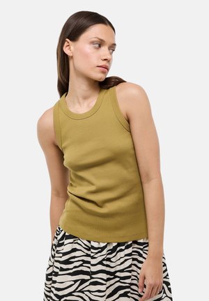 Débardeur côtelé vert olive avec un col rond, doté de larges bretelles, associé à une jupe à imprimé zèbre noir et blanc.