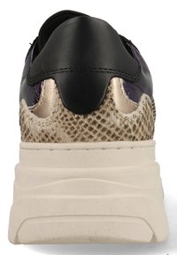 Black leather upper with metallic gold accents; textured tan material at heel; thick cream sole with visible texture.