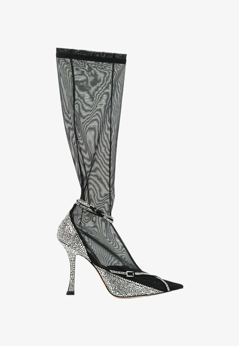 Botte à talon aiguille noire en mesh montant jusqu'au genou, avec bout pointu et talon recouverts de strass, dotée d'une bride et d'une boucle en strass à la cheville.
