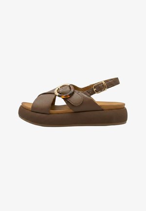 Sandalo platform in pelle marrone con cinturini incrociati, fibbia decorativa rotonda, cinturino regolabile alla caviglia e suola imbottita.