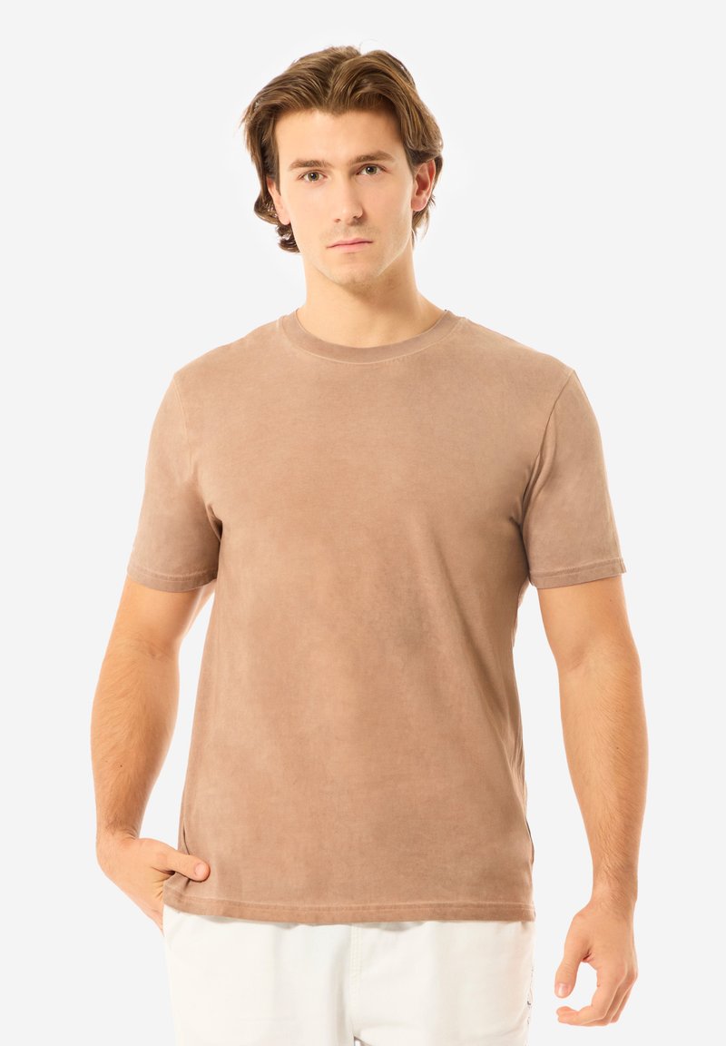 Hellbraunes Kurzarm-T-Shirt aus weichem Material, mit klassischem Rundhalsausschnitt und lockerer Passform. Sanfte Textur, einfaches Design.