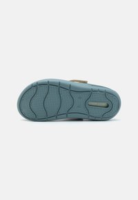 Light blue rubber shoe sole featuring a textured surface with grooves and a small logo printed along the side.