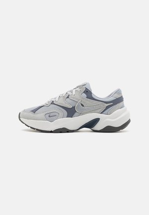 Gray and navy athletic sneaker with mesh and suede upper, white thick sole, and Nike swoosh logo on the side.