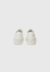 Hvite lær sneakers med en tykk såle. Glatt tekstur med subtile sømdetaljer. Rund tå og minimalmerking på hælen.