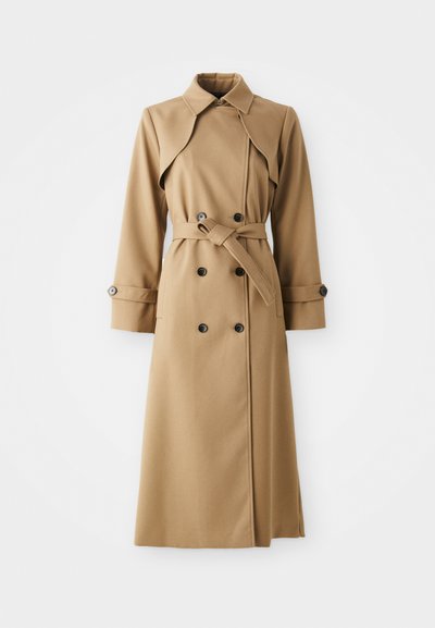 Μπεζ παλτό trench με διπλή σειρά κουμπιών, φαρδύ γιακά, ζώνη στη μέση και μακριά μανίκια. Διαθέτει υφάσματος με σχέδια και κουμπί διακοσμητικά στοιχεία.