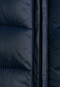 Kurtka puchowa w ciemnogranatowym kolorze z pikowanymi sekcjami, z centralnym zamkiem błyskawicznym i gładką powierzchnią, zaprojektowana z myślą o ciepłocie i izolacji.