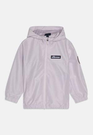 Chaqueta cortaviento de lavanda claro con cremallera frontal, capucha, puños elásticos y un parche con el logo en el pecho. Material liso y resistente al agua.