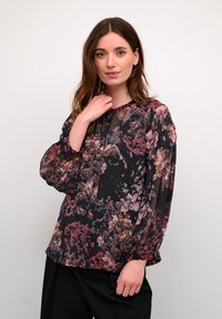 Schwarze Bluse mit floralem Muster, aus transparenter Stoffqualität, langen Ballonärmeln, rundem Ausschnitt und lockerer Passform, mit Akzenten in Pink, Lila und Gold.