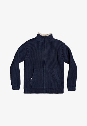 Cardigan en maille côtelée bleu marine à fermeture éclair, avec deux poches avant et un col montant doublé en polaire beige.