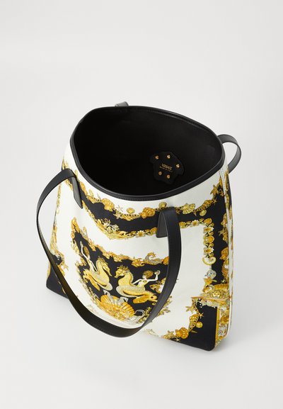 Borsa a spalla con tessuto bianco e nero caratterizzato da una stampa barocca dorata, doppi manici neri e un ampio interno con etichetta del brand.