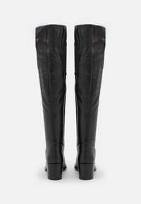 Botas altas de cuero negro con un acabado texturizado, tacón rectangular y detalles de costura vertical en la parte trasera.