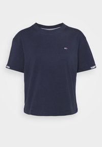 Marinblå kortärmad t-shirt i bomull. Har rundad halsringning och en logotagg på bröstet med "TOMMY JEANS" text på ärmarna.