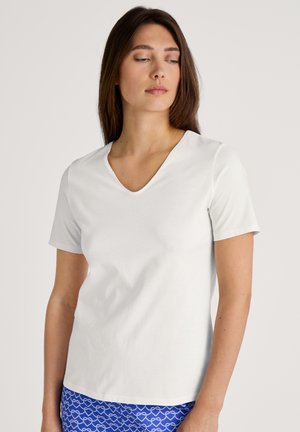 T-shirt bianco a maniche corte con scollo a V realizzato in morbido cotone, caratterizzato da una silhouette rilassata e cuciture minime per un design pulito.