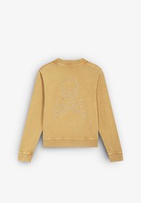 Felpa gialla con scollatura rotonda, polsini a coste e un design di teschio e ossa incrociate in strass sulla schiena. Tessuto di cotone morbido.