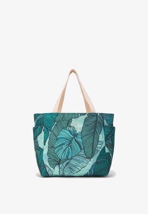 Tote taske med stort, grønt tropisk bladmotiv, cremefarvede håndtag og forlommer med guldfarvet "DEHA"-logo.