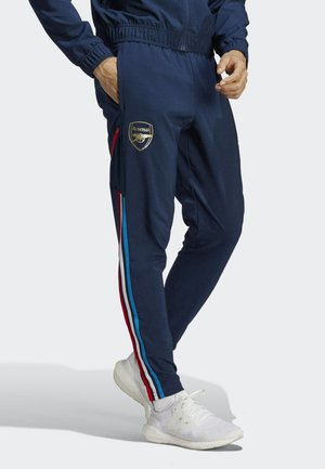 Navy tracksuit pants with elastic waistband, featuring a gold Arsenal logo and multi-colored stripes in red, blue, and white along the sides.