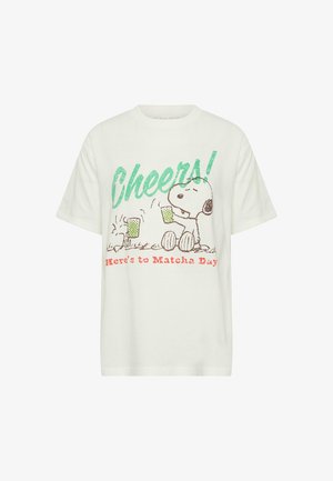 White T-shirt with Snoopy holding a green drink, text "Cheers!" in green, and "Here's to Matcha Day" in red below.