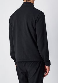 Schwarze Fleecejacke mit Kragen, geradem Schnitt und langen Ärmeln. Der Stoff hat eine glatte Textur ohne sichtbare Muster oder Akzente.