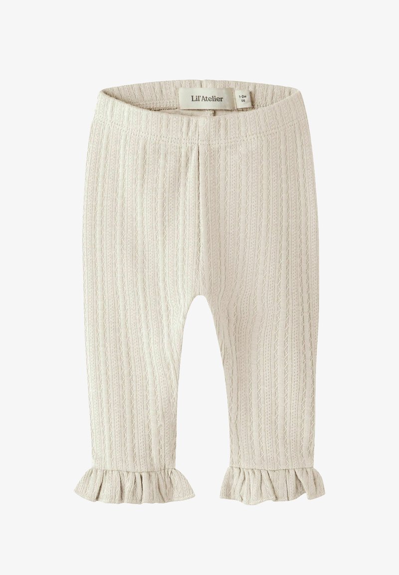 Leggings bébé côtelés couleur crème avec ourlets à volants, ceinture élastique et petite étiquette de taille à l'intérieur de la taille.