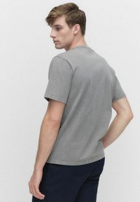 Grå bomulds T-shirt med korte ærmer, rund halsudskæring og en let afslappet pasform. Stoffet har en glat overflade og et minimalistisk design.