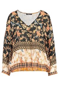 Blouse à manches longues avec encolure en V, motifs floraux et géométriques en noir, crème et moutarde, ourlet élastique et coupe décontractée.