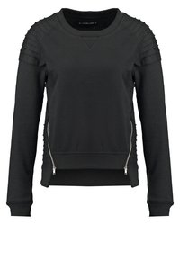 Sweat-shirt noir à manches longues avec épaules côtelées, encolure ronde et deux fermetures éclair argentées verticales sur les côtés avant.