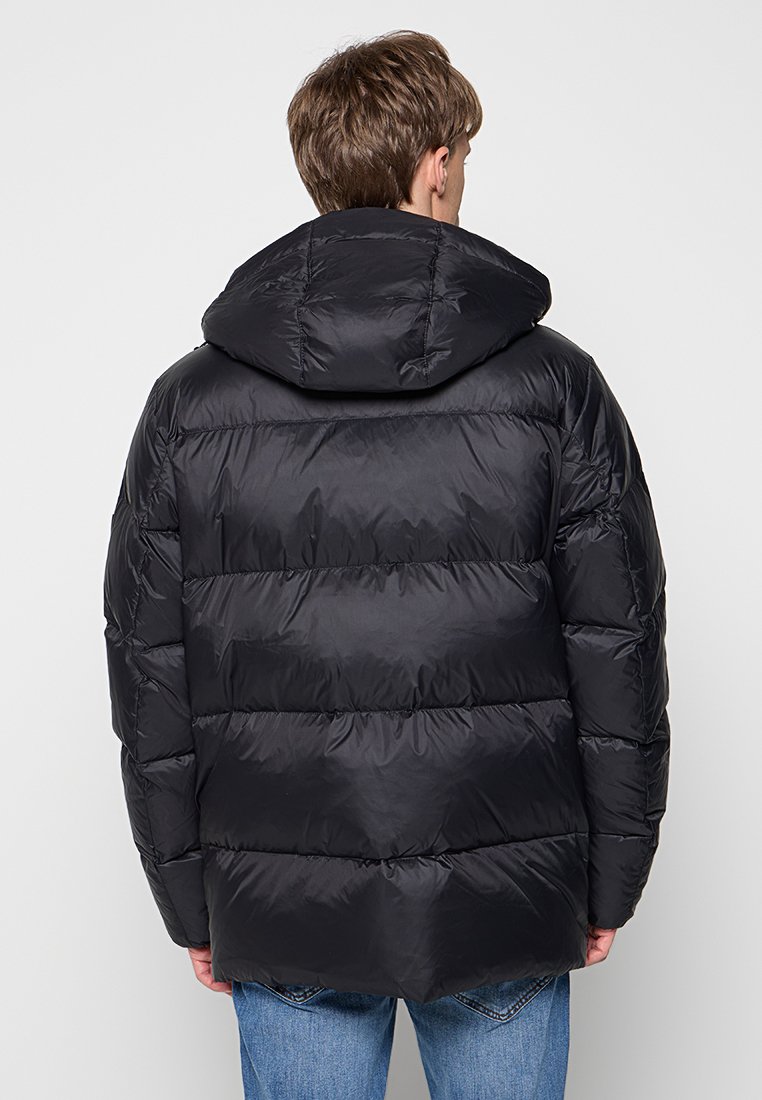 Schwarze Pufferjacke mit Kapuze, die ein gestepptes Design und eine glänzende Oberfläche aufweist. Die Jacke hat einen lässigen Schnitt und gerippte Bündchen.